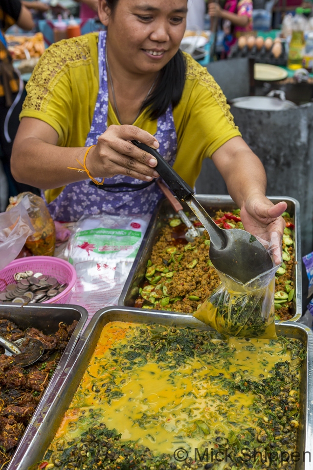Bagging up a curry in a local market, Bangkok.