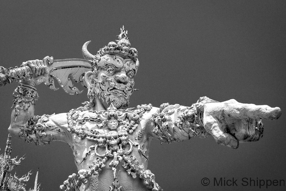 A statue of a mythical figure at Wat Rong Khun, the White Temple, by renowned by artist Chalermchai Kositpipat.