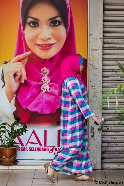 A Muslim woman walking passed a shop in Masjid India, Kuala Lumpur, Malaysia