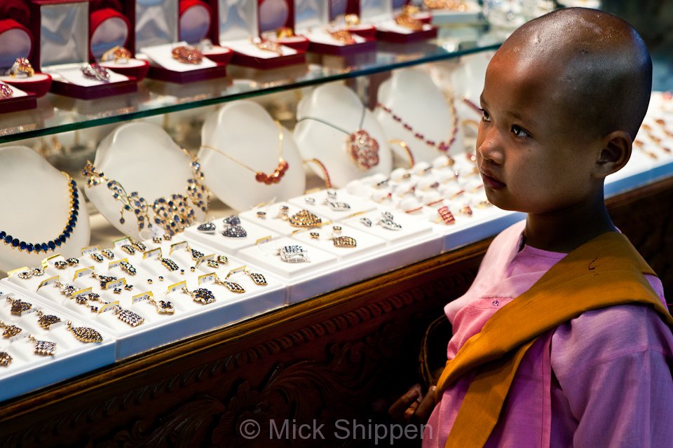 A novice nun waits in vain for a donation at a gold shop in the Scott Market, also lnon as Bogyoke Market.