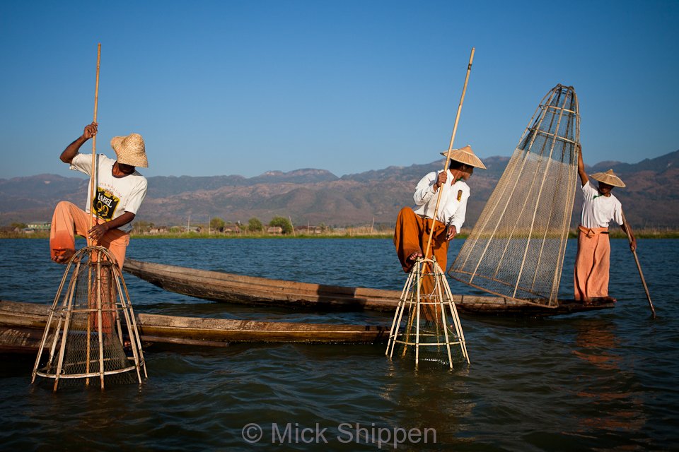 Leg rowing fishermen on the lake using the distinctive traditional fishing baskets and nets.